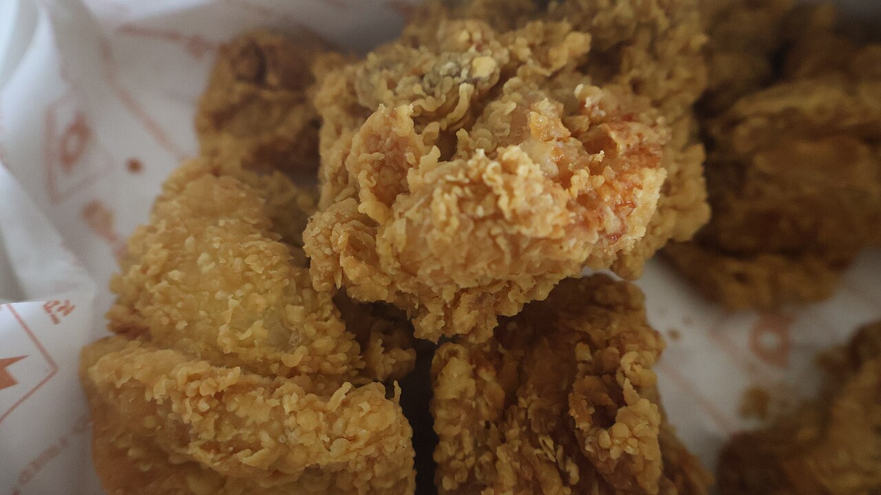 Crispy golden fried chicken pieces in a paper-lined box