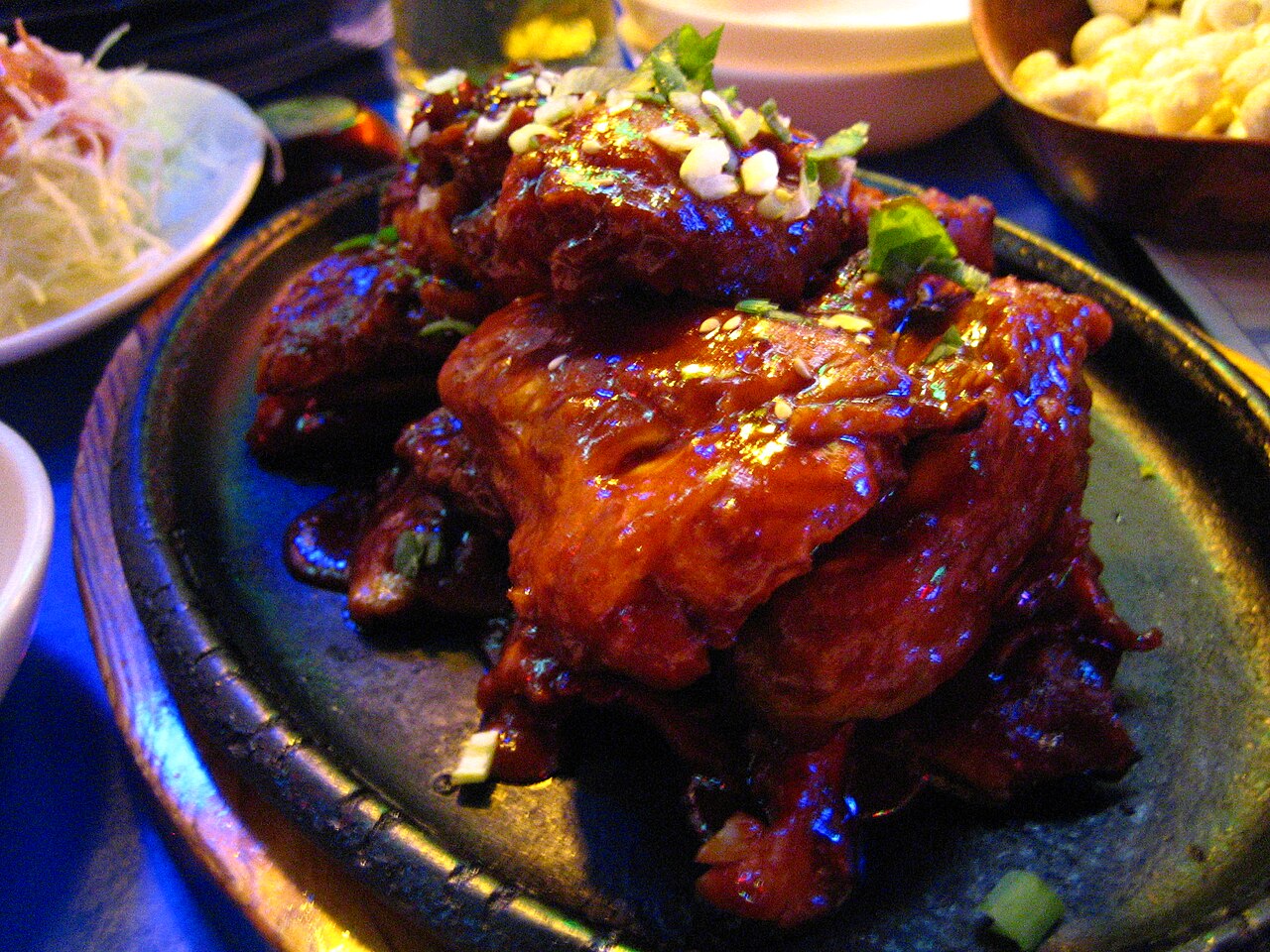 Fried chicken glazed in a dark red sweet and spicy sauce on a plate