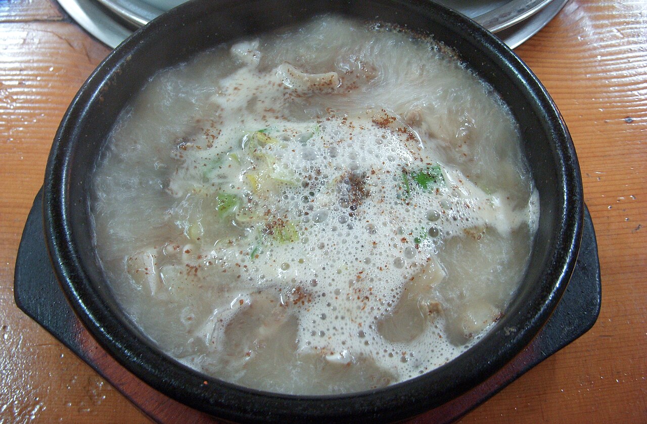 A pot of pork gukbap with a milky broth