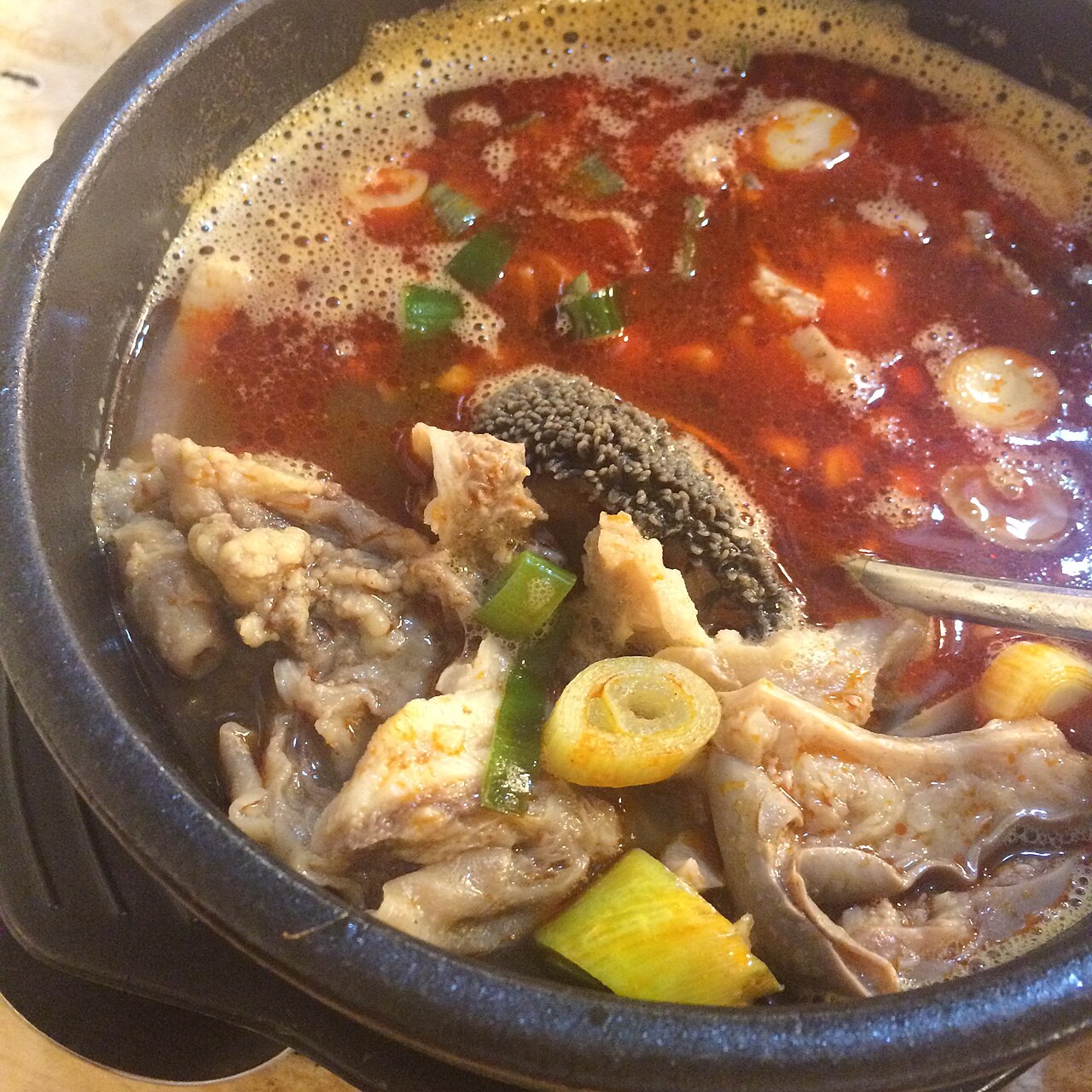 A bowl of spicy haejang-guk with beef offal, ox blood curd and scallions