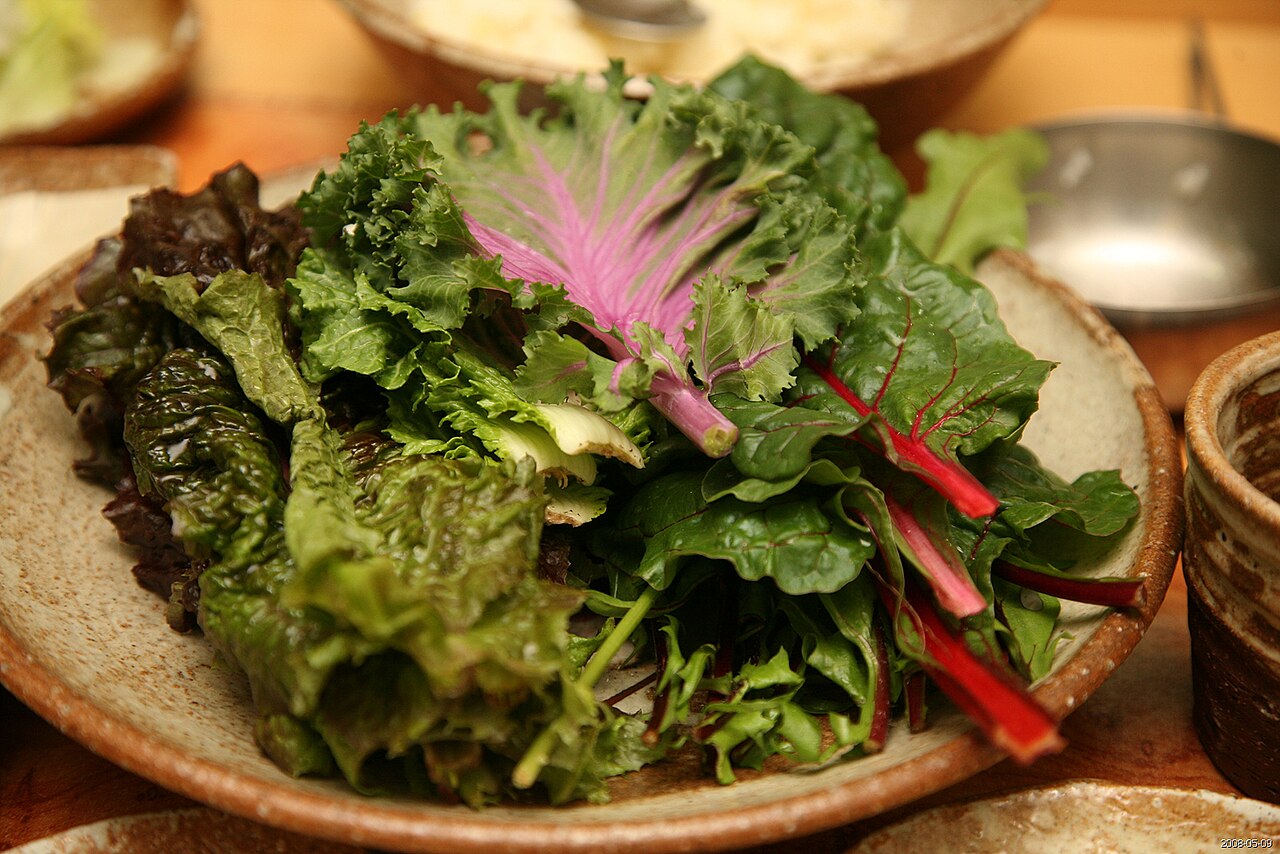 A plate of fresh ssam leaves: red leaf lettuce, kale, chard and other leafy greens