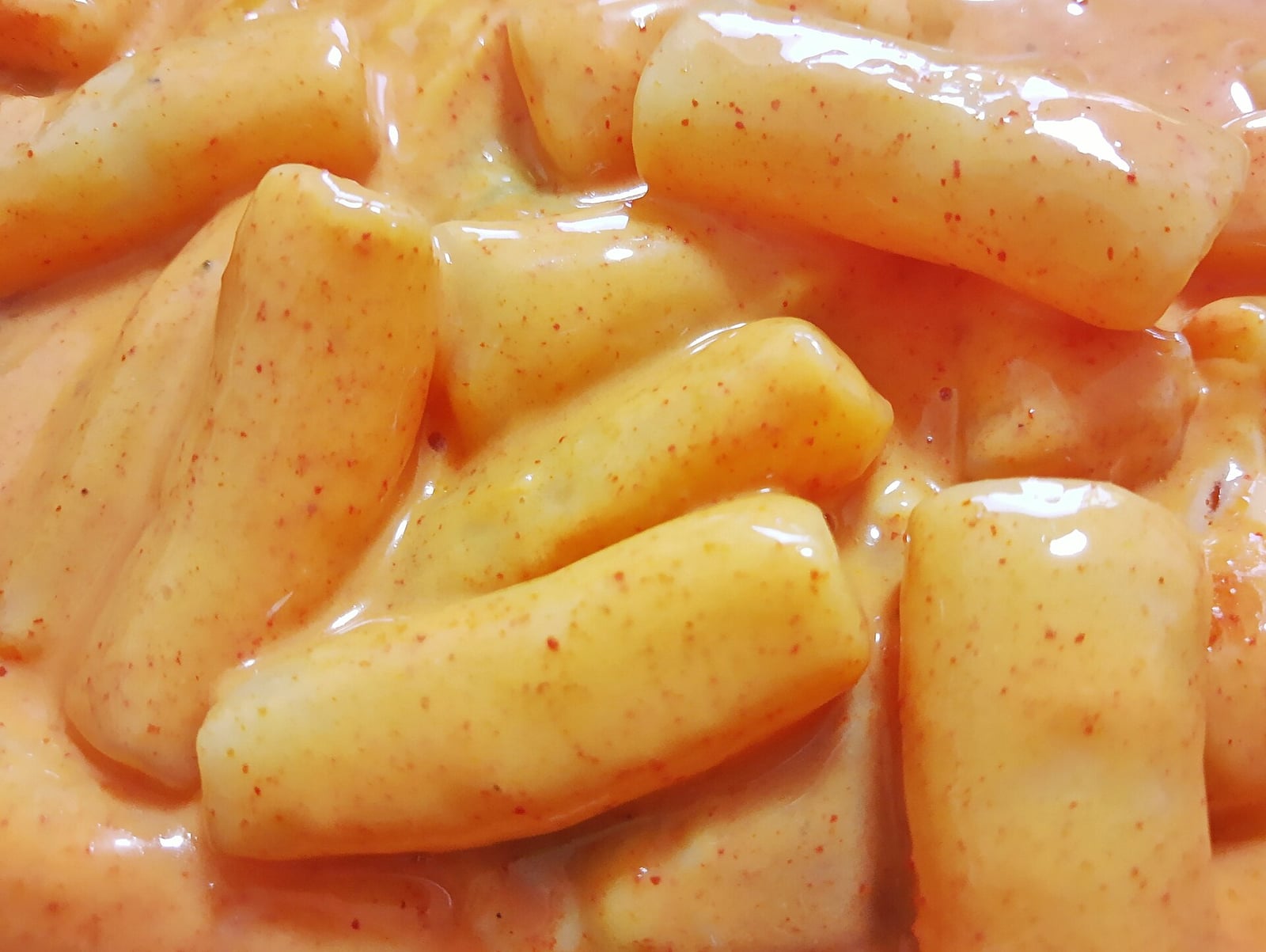 Rice cakes coated in a creamy orange-pink rosé sauce